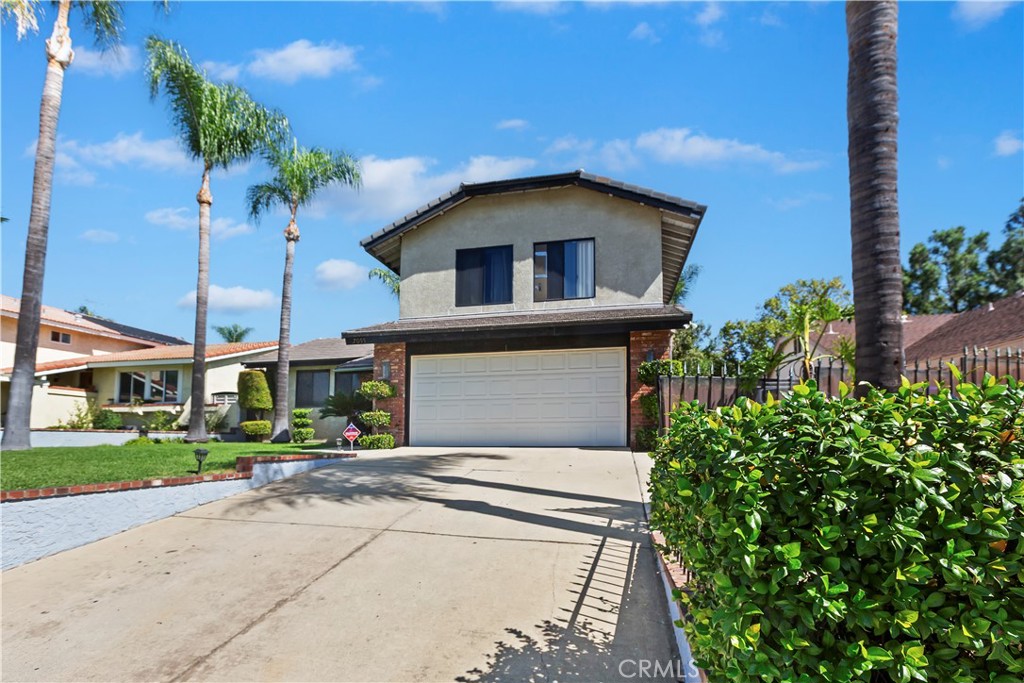 7055 Mango Street Rancho Cucamonga, CA 91701 - Photo 2 of 32 a front view of a house with a yard and potted plants