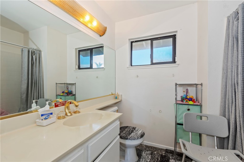 7055 Mango Street Rancho Cucamonga, CA 91701 - Photo 24 of 32 a bathroom with a sink mirror and toilet