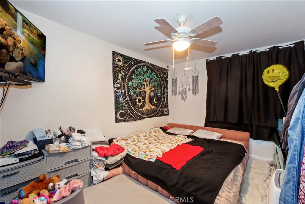 7055 Mango Street Rancho Cucamonga, CA 91701 - Photo 27 of 32 a bedroom with a bed and a chandelier