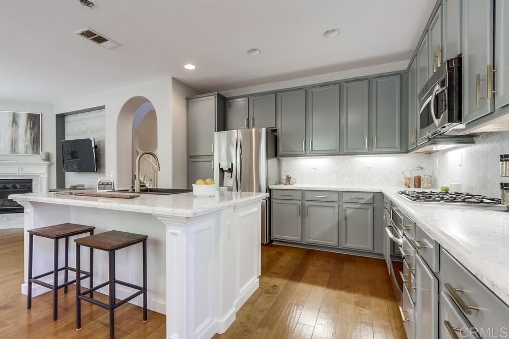 3400 Filoli Circle Carlsbad, CA 92009 - Photo 12 of 42 a kitchen with stainless steel appliances granite countertop a stove a sink and a refrigerator