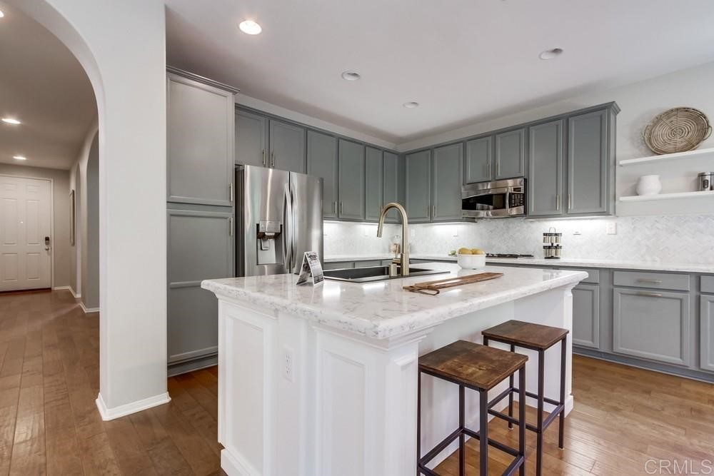 3400 Filoli Circle Carlsbad, CA 92009 - Photo 13 of 42 a kitchen with kitchen island a refrigerator stove microwave and cabinets