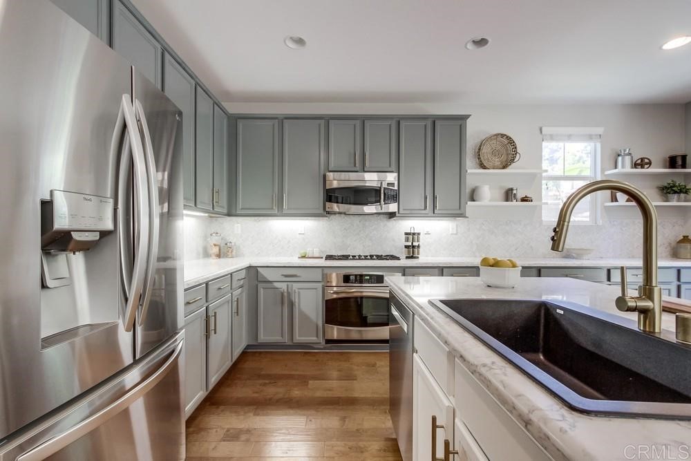 3400 Filoli Circle Carlsbad, CA 92009 - Photo 14 of 42 a kitchen with stainless steel appliances granite countertop a sink stove and refrigerator
