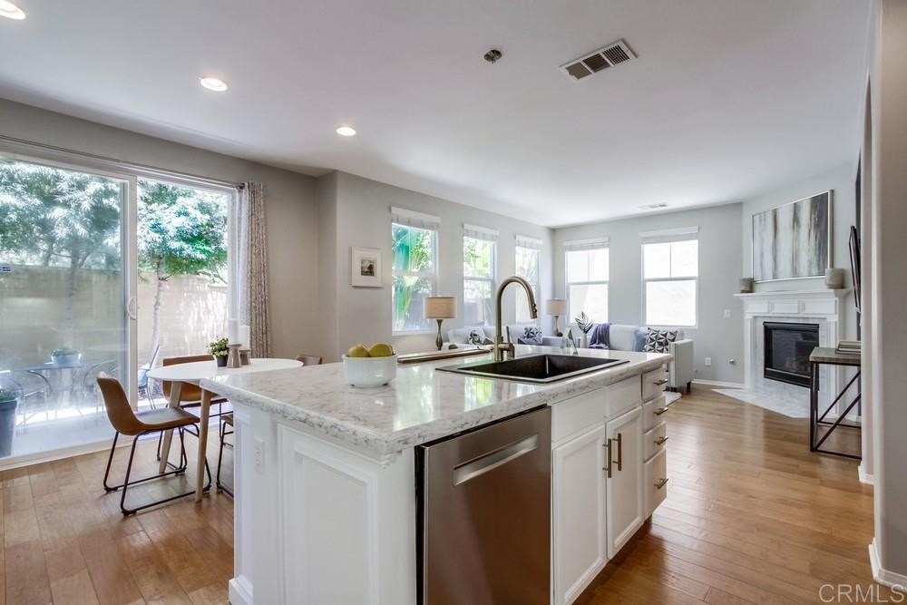 3400 Filoli Circle Carlsbad, CA 92009 - Photo 15 of 42 a kitchen with a stove a sink a dining table and chairs