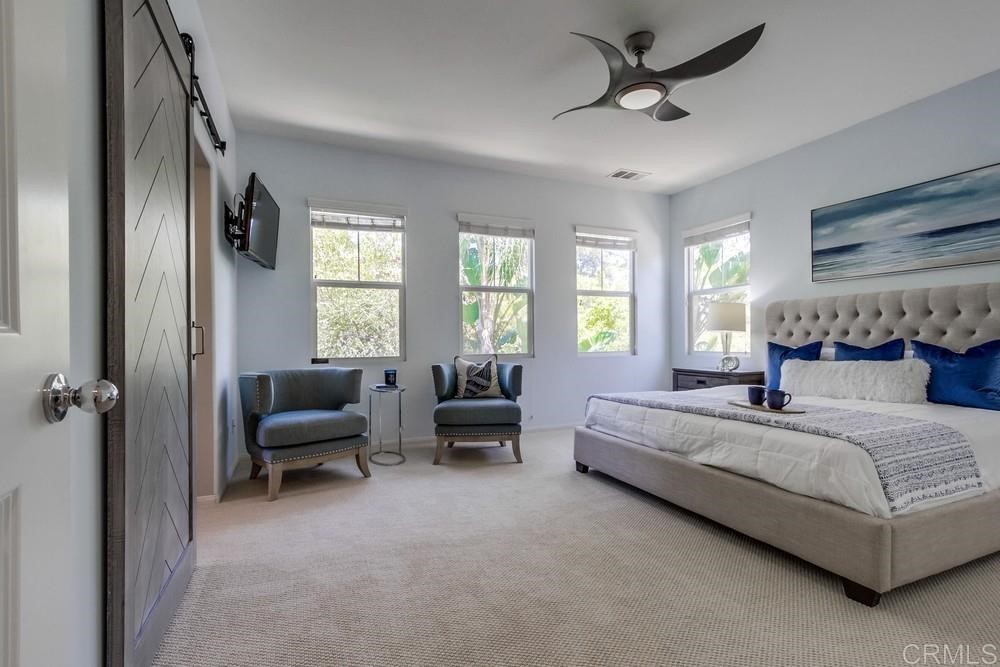 3400 Filoli Circle Carlsbad, CA 92009 - Photo 21 of 42 a spacious bedroom with a bed and a chandelier