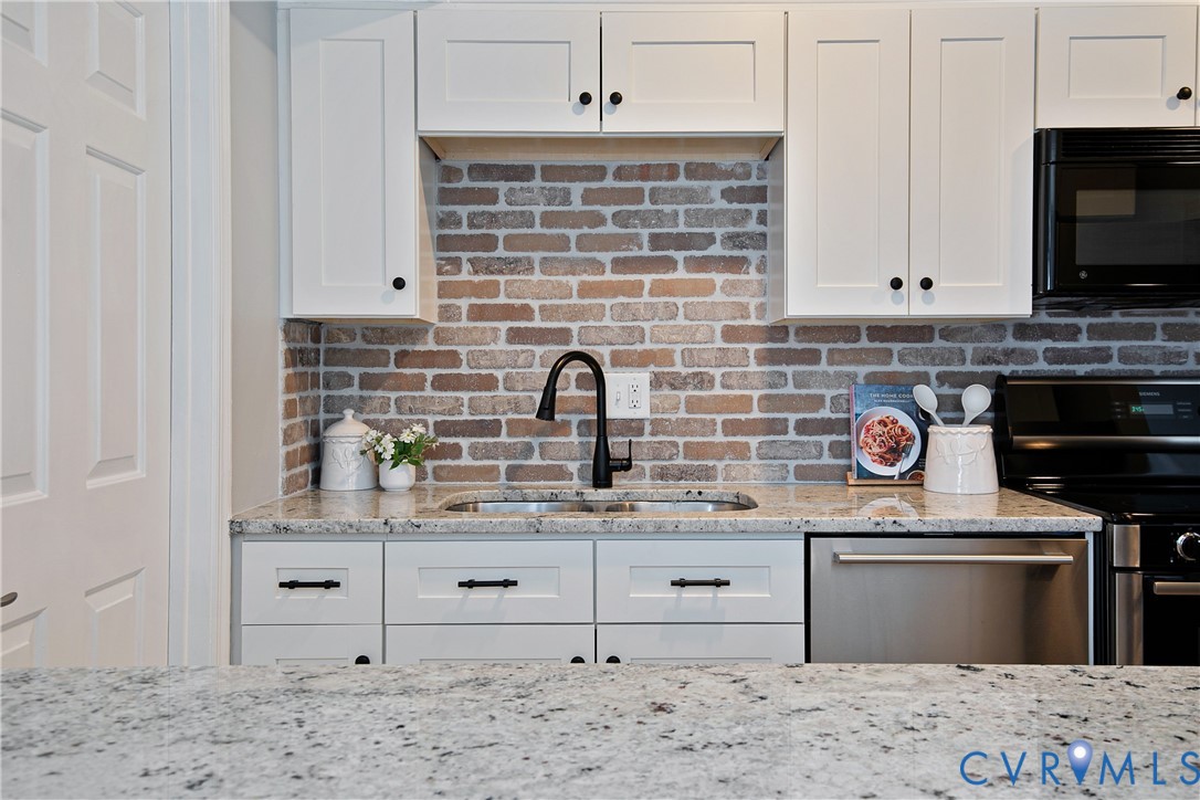 34 Brandywine Court Colonial Heights, VA 23834 - Photo 16 of 30 a kitchen with stainless steel appliances kitchen island granite countertop a stove a sink and a microwave