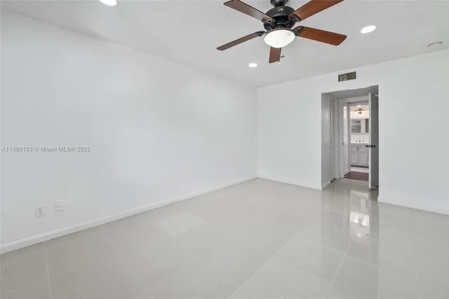 an empty room with closet and a chandelier fan