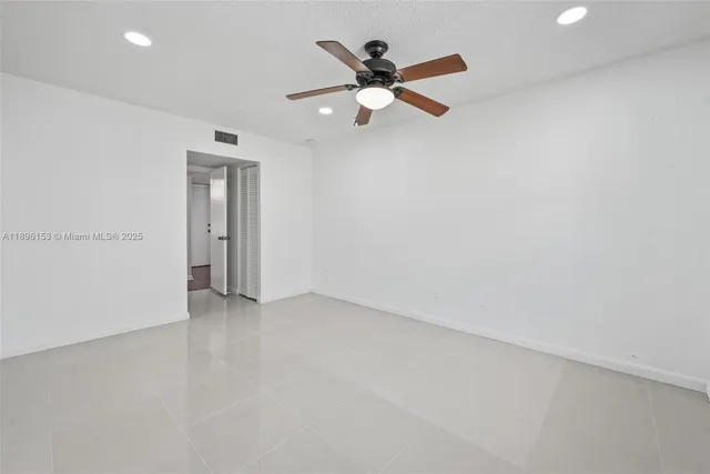 an empty room with closet and ceiling fan