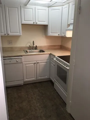 a kitchen with granite countertop cabinets stainless steel appliances and a sink