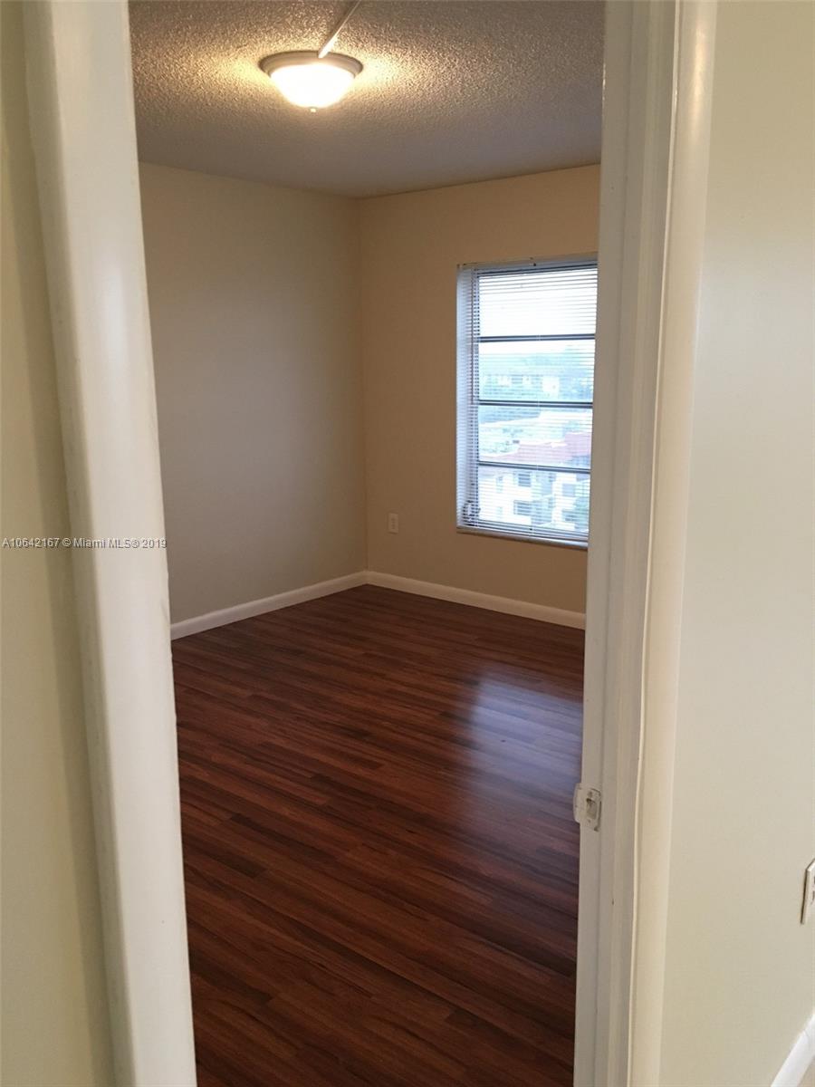 4164 Inverrary Drive, Unit 813 Lauderhill, FL 33319 - Photo 18 of 25 a view of an empty room with wooden floor and a window