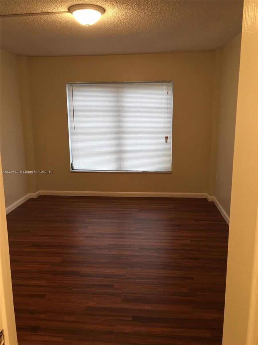 4164 Inverrary Drive, Unit 813 Lauderhill, FL 33319 - Photo 20 of 25 an empty room with wooden floor and windows