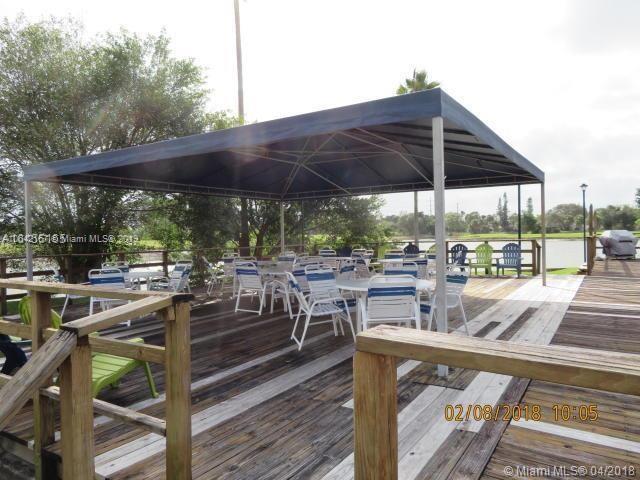 4164 Inverrary Drive, Unit 813 Lauderhill, FL 33319 - Photo 3 of 25 a view of a patio with chairs and table under an umbrella
