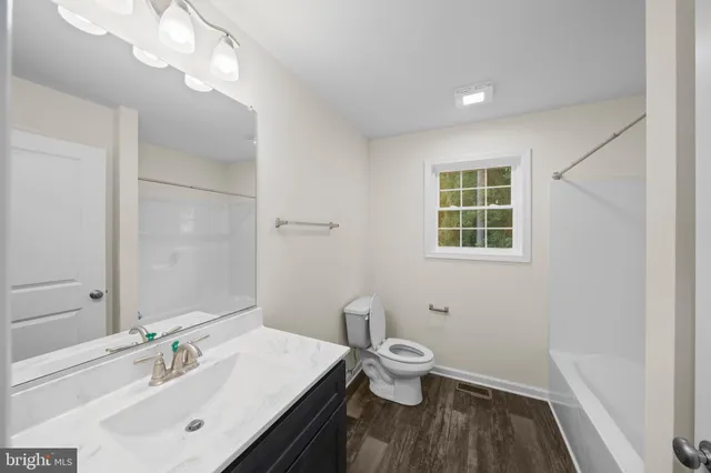 a bathroom with a sink toilet and a mirror