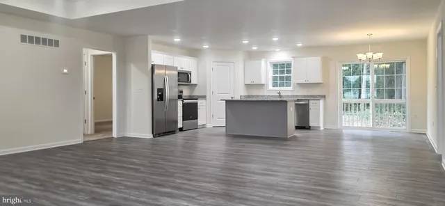 a view of kitchen with stainless steel appliances granite countertop a refrigerator stove top oven and sink