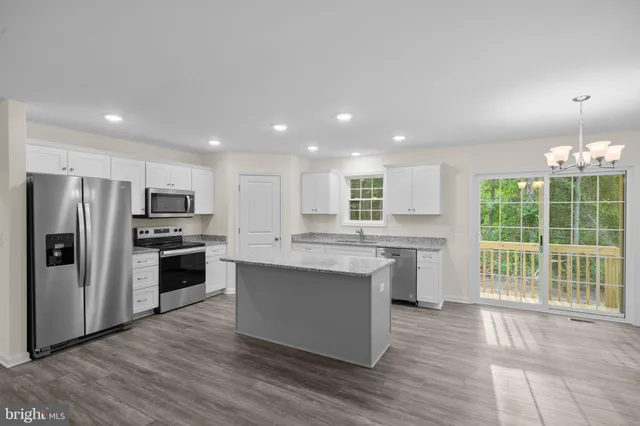 a kitchen with stainless steel appliances granite countertop a refrigerator stove top oven and sink