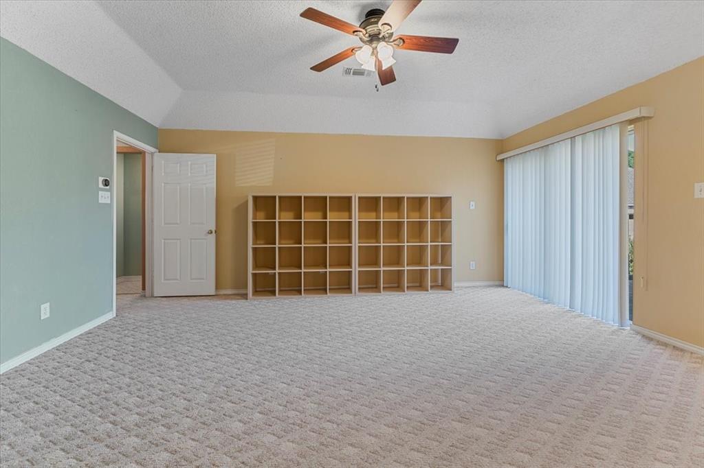 6752 MacIntosh Drive Plano, TX 75023 - Photo 18 of 40 Carpeted spare room with a textured ceiling, lofted ceiling, and ceiling fan