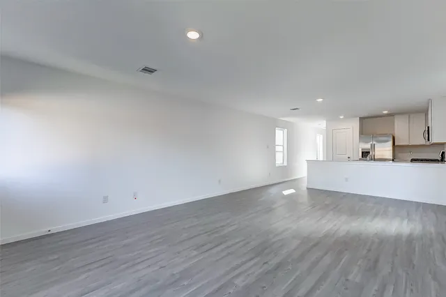 a view of a kitchen with wooden floor and a sink