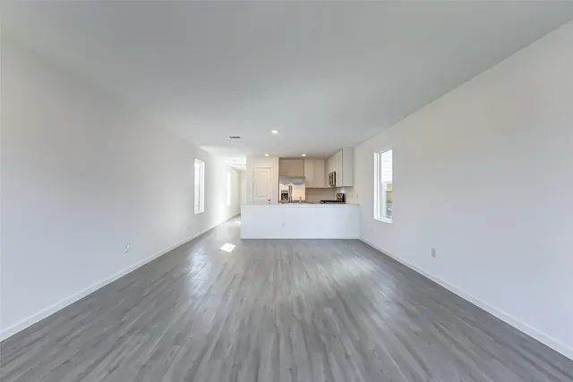 a view of a kitchen with wooden floor and windows
