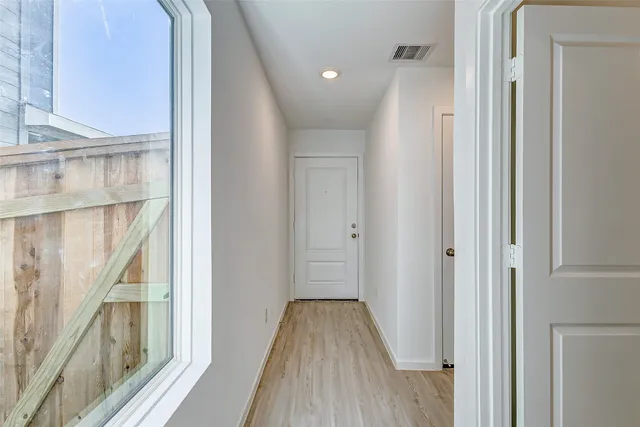 a view of a hallway with wooden floor and staircase