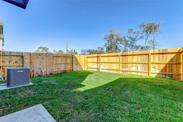 a view of a house with a yard and wooden fence