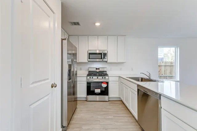 a kitchen with stainless steel appliances granite countertop a stove and a refrigerator