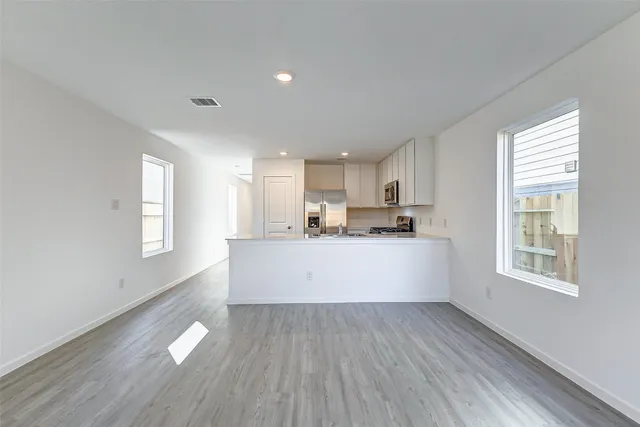 a view of kitchen with windows and wooden floor