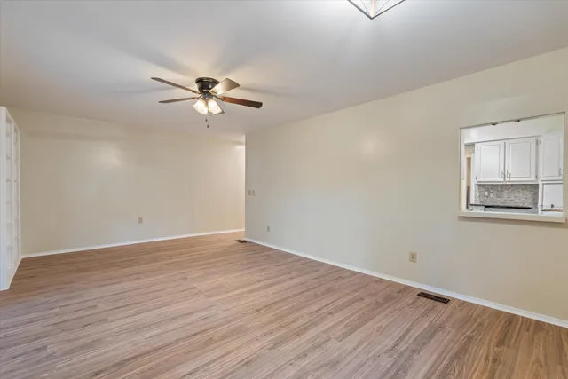 an empty room with floor to ceiling windows and city view