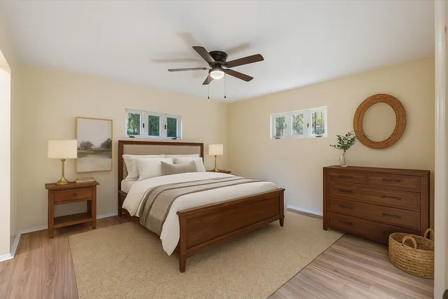 an empty room with wooden floor ceiling fan and windows