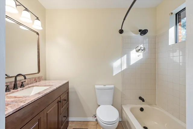 a bathroom with a granite countertop sink a toilet and a mirror