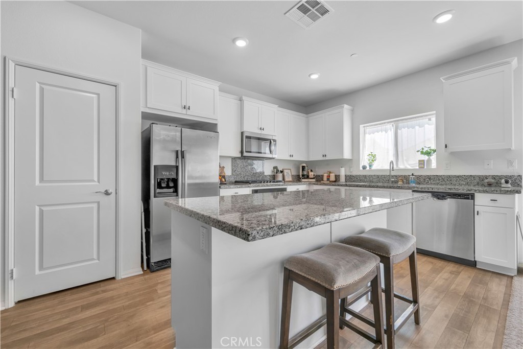 4422 Jade Court Lancaster, CA 93536 - Photo 27 of 44 a kitchen with stainless steel appliances granite countertop a white cabinets and a refrigerator