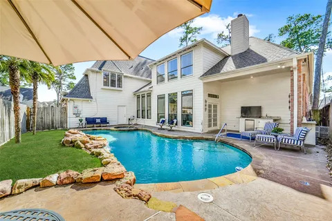 a view of a house with swimming pool and sitting area