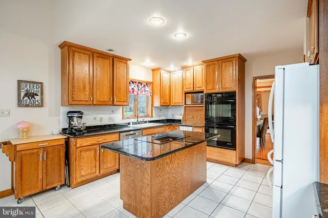 a kitchen with stainless steel appliances granite countertop a refrigerator a sink and a stove