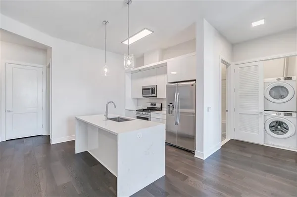 a kitchen with a refrigerator sink and cabinets