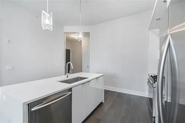 a kitchen with a sink a refrigerator and chandelier