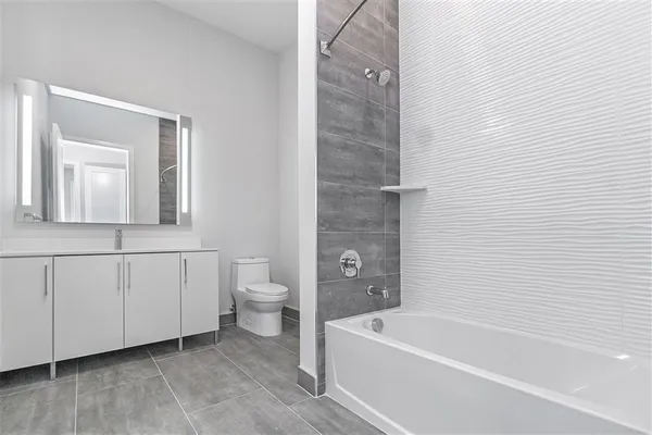 a bathroom with a white bath tub a mirror and a toilet