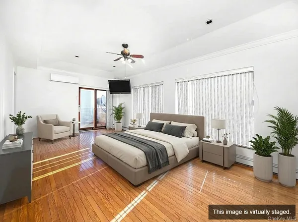 a spacious bedroom with a large bed a potted plant and a window