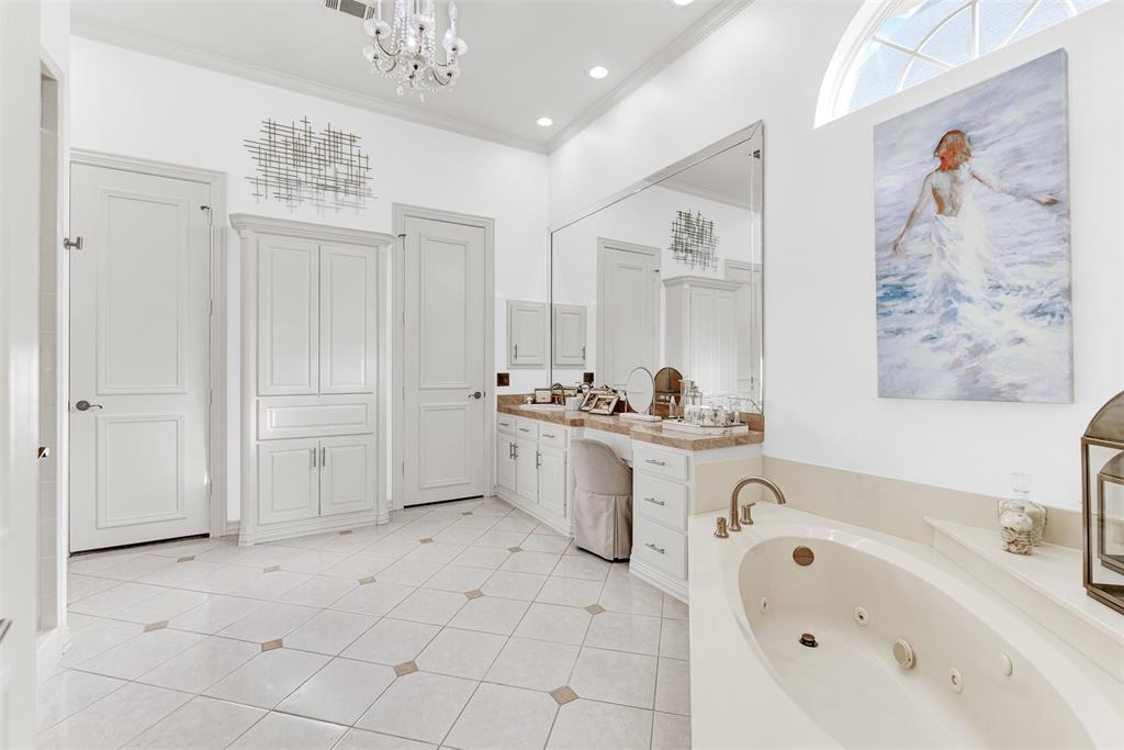 2605 Rutgers Court Plano, TX 75093 - Photo 23 of 34 Step into your private spa! Cool tiled floor pairs with the dual vanities and jetted tub to provide the ultimate in relaxation. Additional storage is everywhere you look to keep linens, towels and toiletries handy, but out of sight!