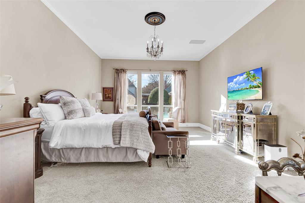 2605 Rutgers Court Plano, TX 75093 - Photo 25 of 34 You'll feel like royalty in this expansive primary bedroom with gorgeous chandelier, plush carpeting and large window displaying relaxing pool and backyard views!