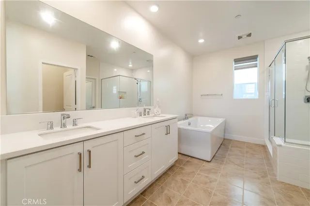 a spacious bathroom with a double vanity sink mirror and bathtub