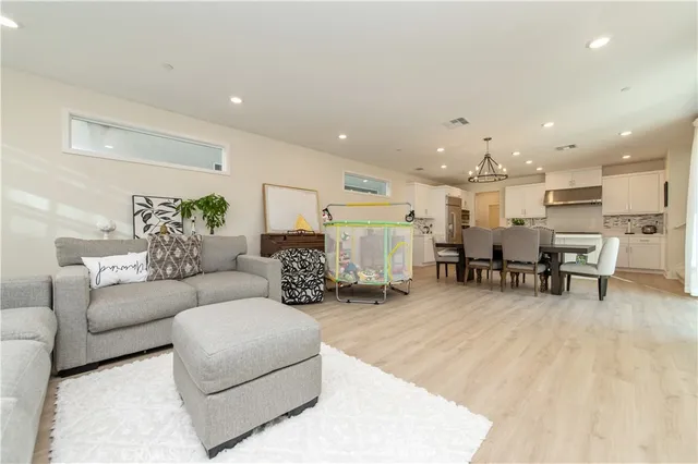 a living room with furniture and kitchen view with a large window