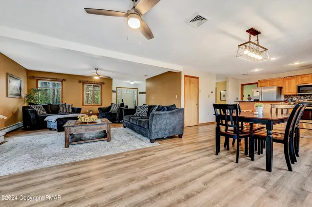 a kitchen with stainless steel appliances granite countertop a refrigerator a sink a stove top oven and a counter space