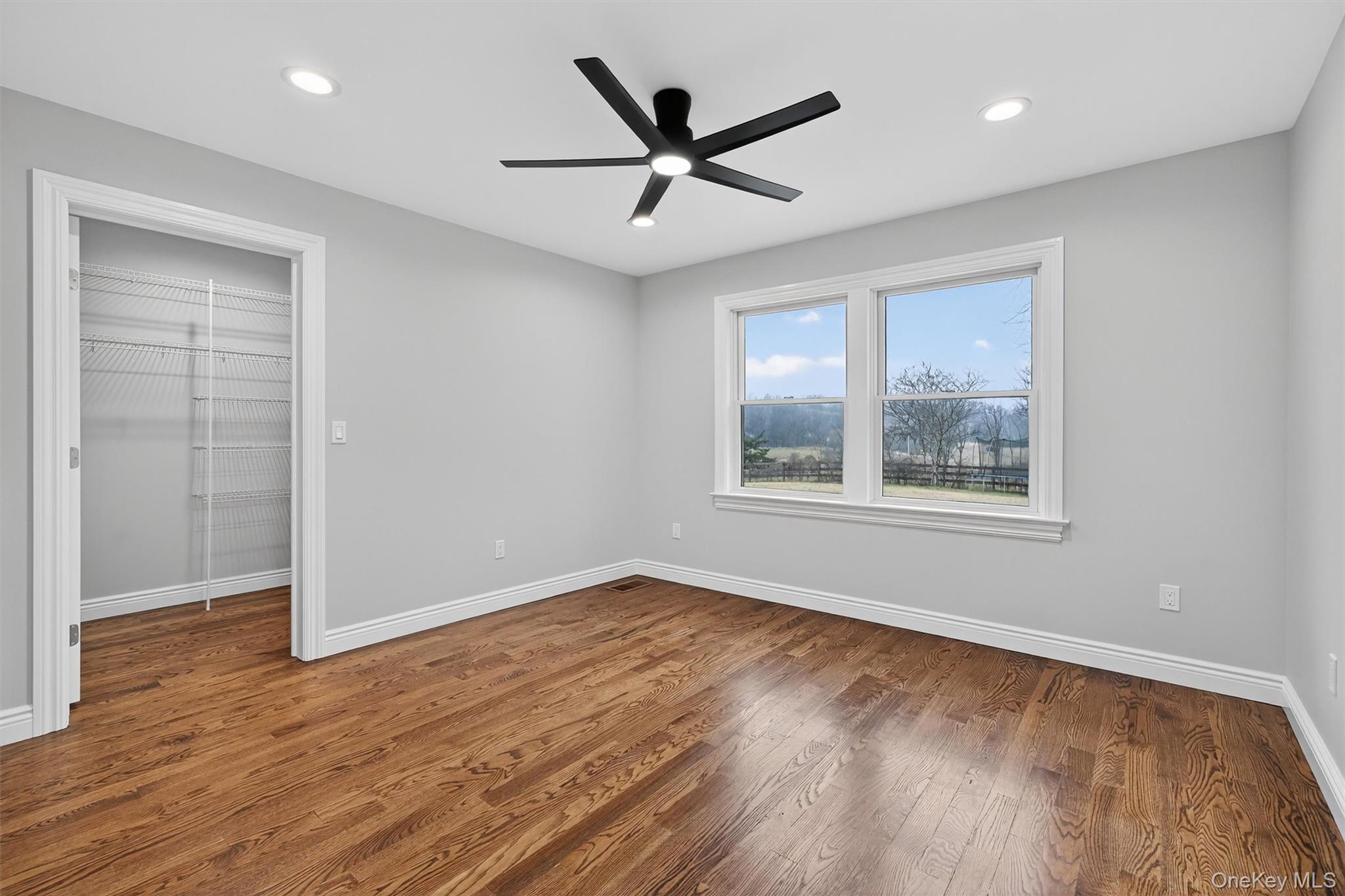 3 Little York Road Warwick, NY 10990 - Photo 21 of 39 an empty room with wooden floor ceiling fan and windows
