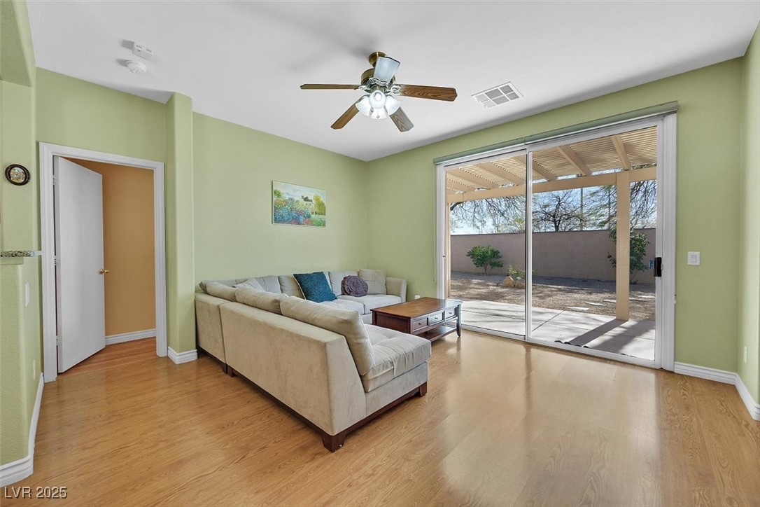 10983 Pumpkin Ridge Avenue Las Vegas, NV 89135 - Photo 11 of 35 Living room with light wood finished floors, baseboards, visible vents, and ceiling fan