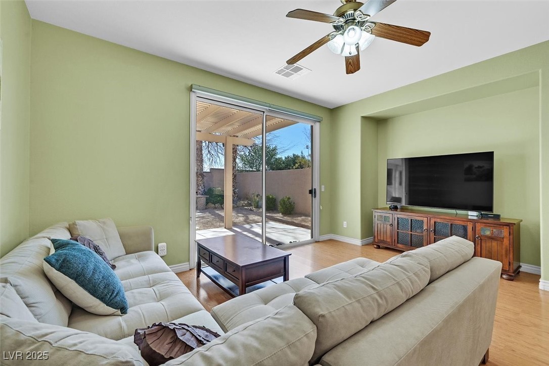 10983 Pumpkin Ridge Avenue Las Vegas, NV 89135 - Photo 12 of 35 Living room with light wood-type flooring, baseboards, visible vents, and a ceiling fan