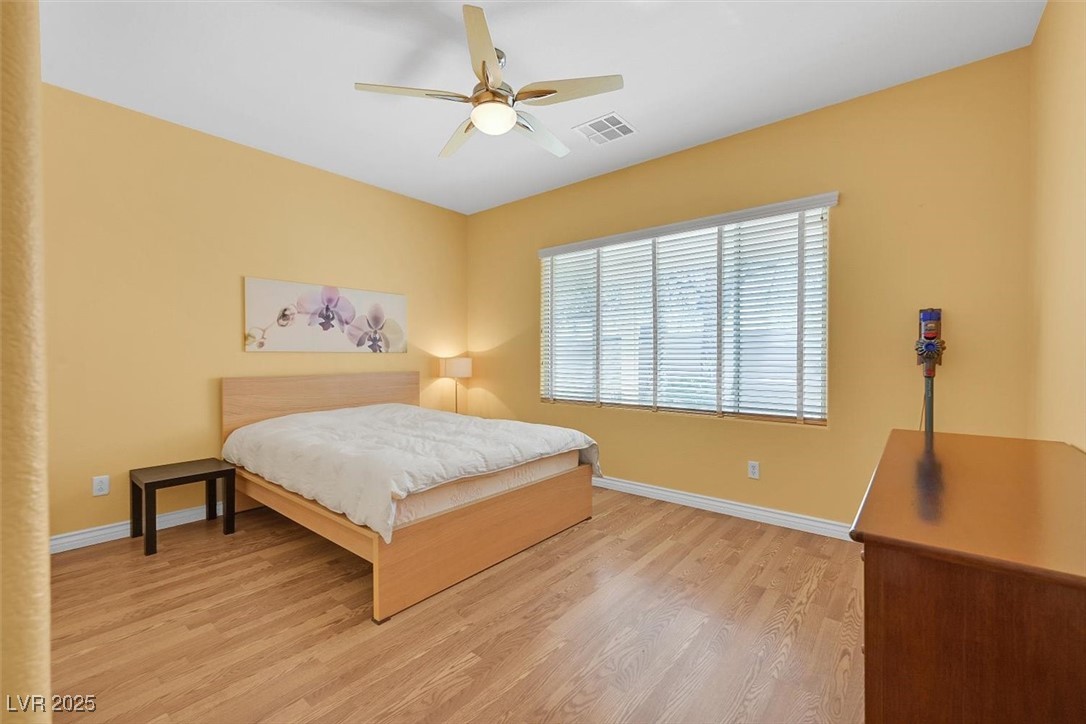 10983 Pumpkin Ridge Avenue Las Vegas, NV 89135 - Photo 14 of 35 Bedroom with a ceiling fan, light wood-type flooring, visible vents, and baseboards