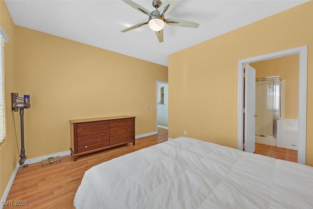 10983 Pumpkin Ridge Avenue Las Vegas, NV 89135 - Photo 15 of 35 Bedroom with ensuite bathroom, ceiling fan, baseboards, and wood finished floors