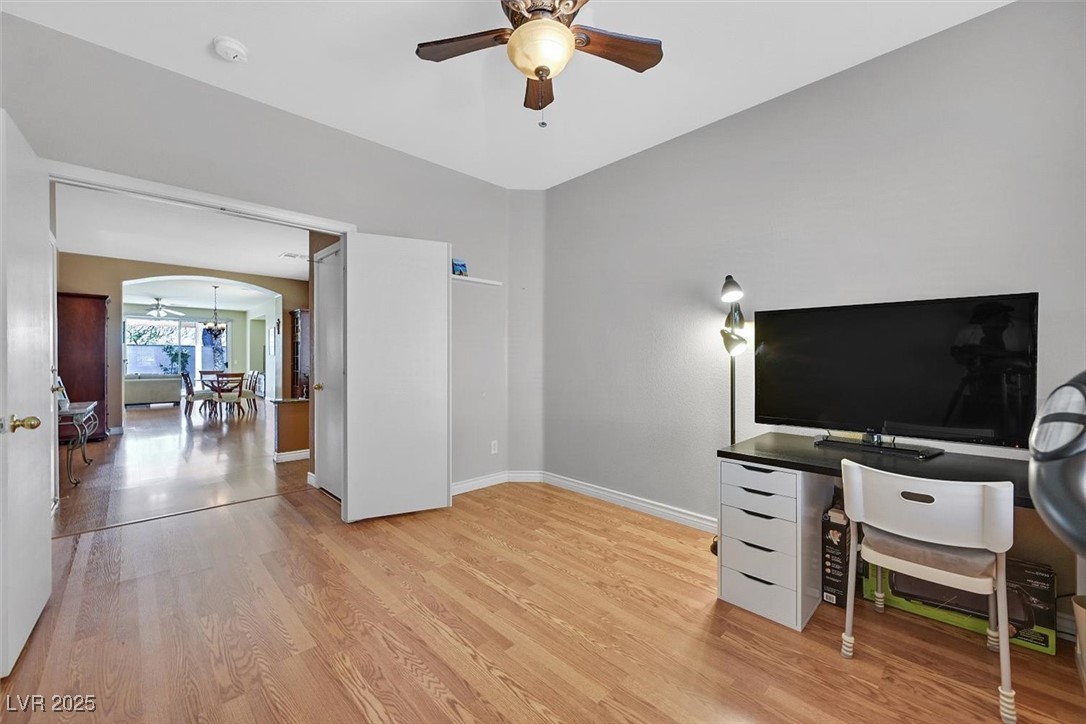 10983 Pumpkin Ridge Avenue Las Vegas, NV 89135 - Photo 20 of 35 Office featuring arched walkways, ceiling fan, light wood-style flooring, and baseboards