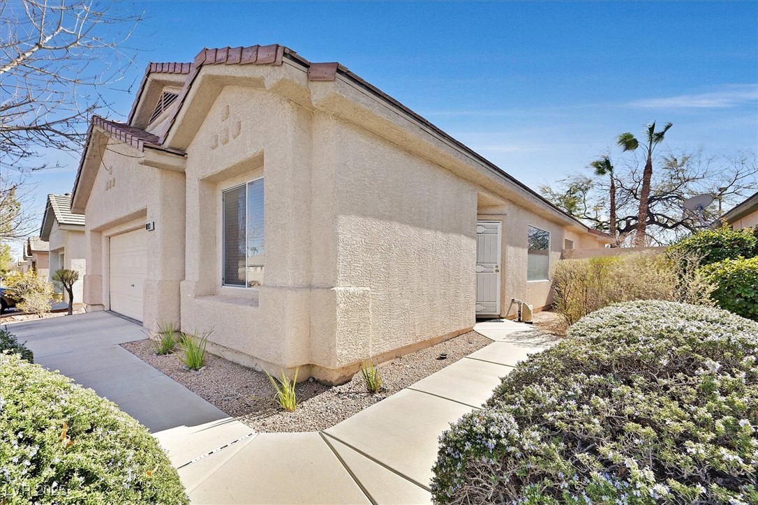 10983 Pumpkin Ridge Avenue Las Vegas, NV 89135 - Photo 2 of 35 View of home's exterior with a garage, driveway, a tiled roof, and stucco siding