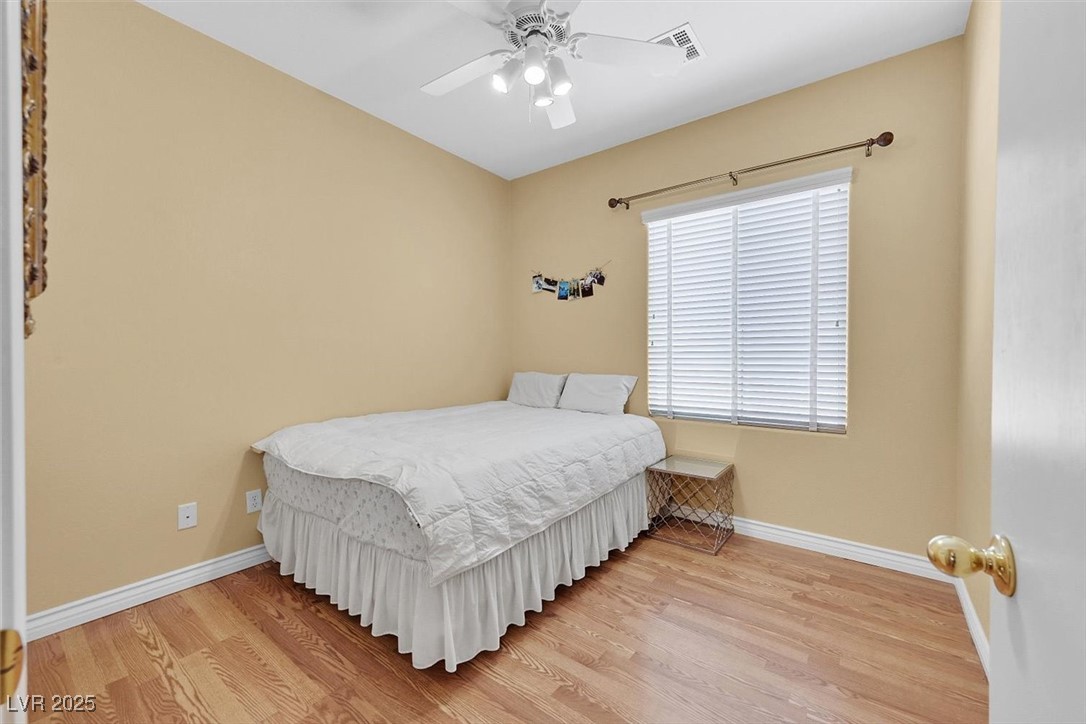 10983 Pumpkin Ridge Avenue Las Vegas, NV 89135 - Photo 22 of 35 Bedroom with visible vents, ceiling fan, baseboards, and wood finished floors