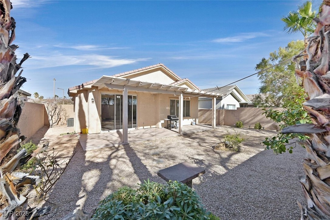 10983 Pumpkin Ridge Avenue Las Vegas, NV 89135 - Photo 27 of 35 Back of property with a patio area, stucco siding, a fenced backyard, and a pergola