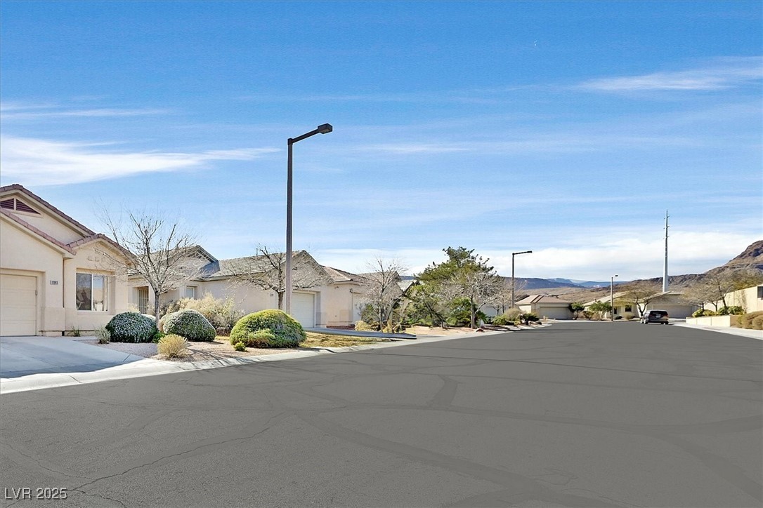 10983 Pumpkin Ridge Avenue Las Vegas, NV 89135 - Photo 28 of 35 View of road with curbs, street lighting, sidewalks, and a residential view